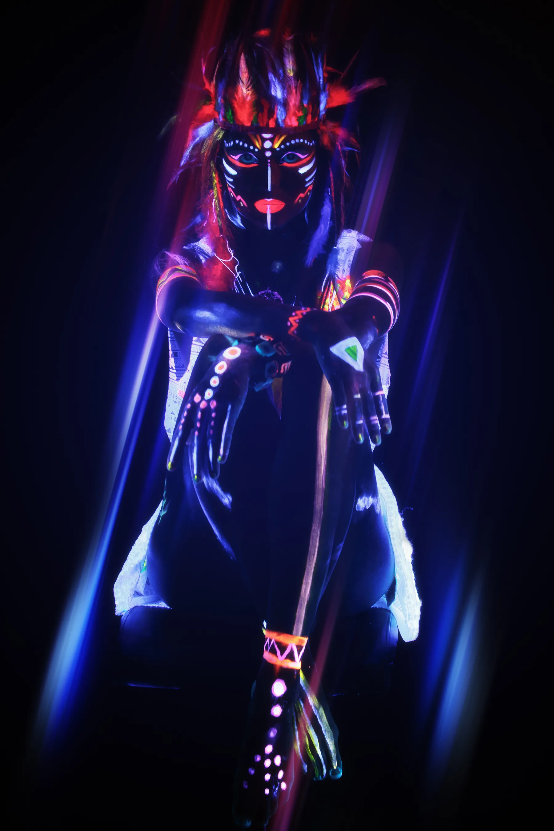 Figura Tribal con Pintura Neon y Plumas